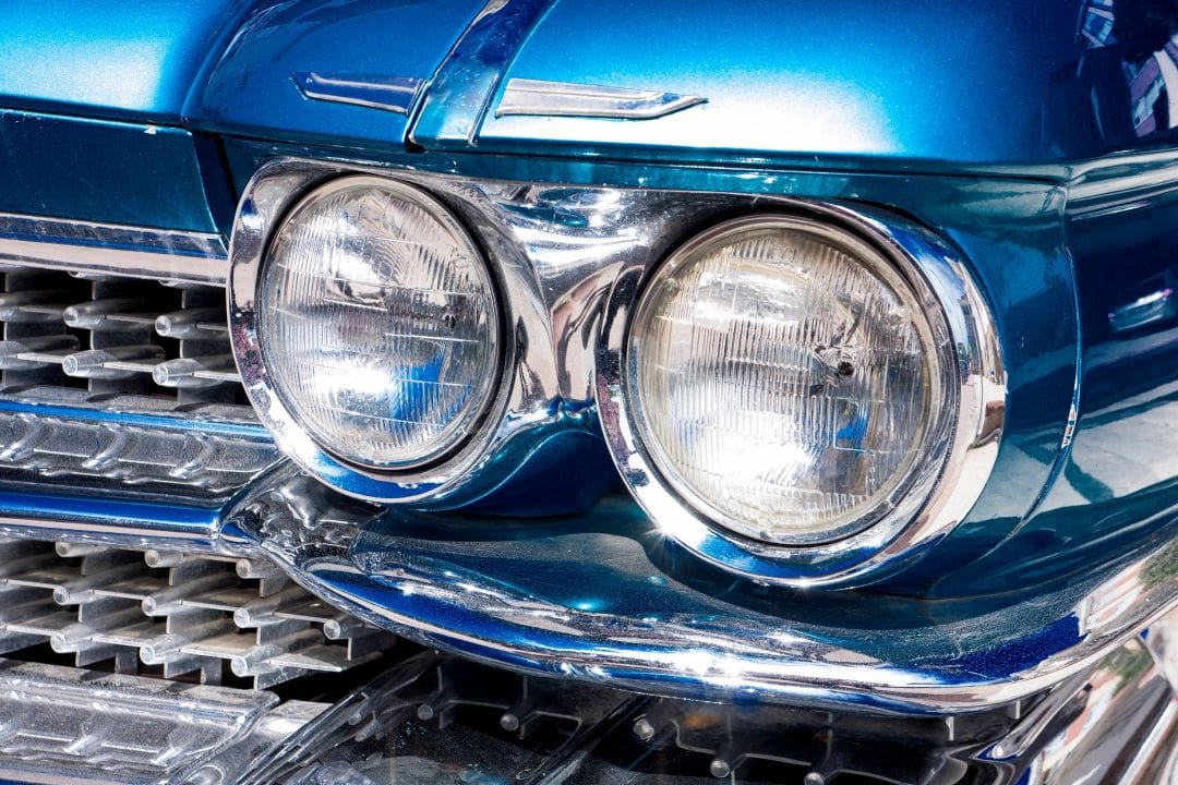 A close up of the headlights on a blue car