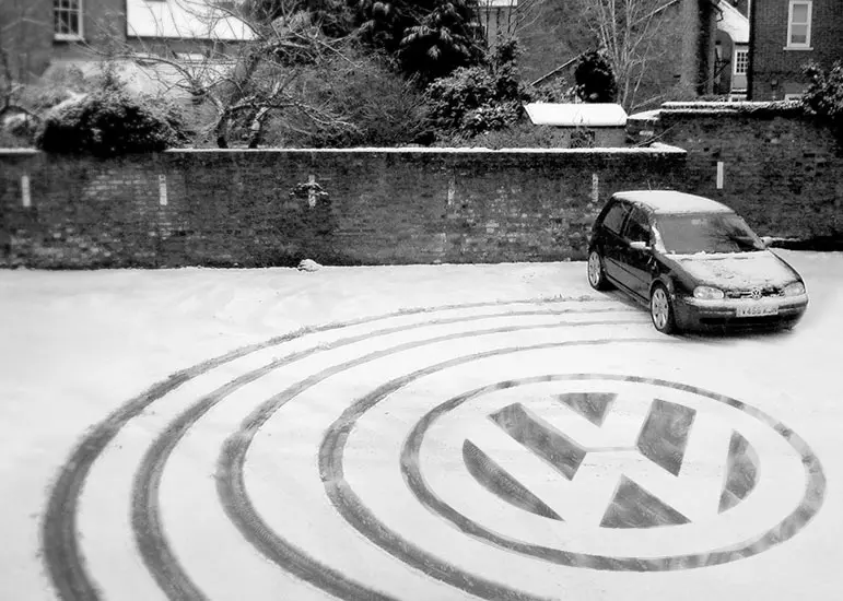 A car parked in the middle of a circular driveway.