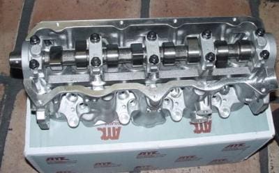 Silver engine cylinder head with camshaft.