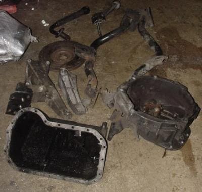 Car engine parts on a garage floor.