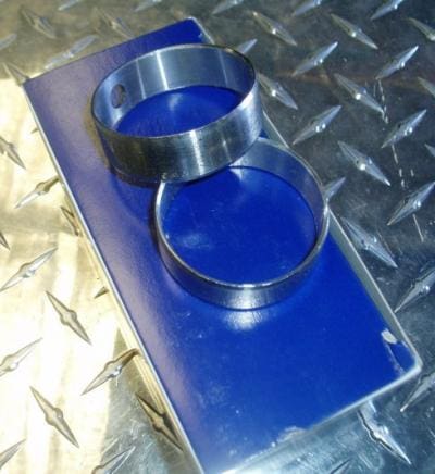 Two silver engine bearing rings on blue box.