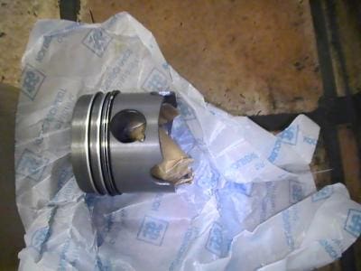 Metal piston wrapped in white paper.